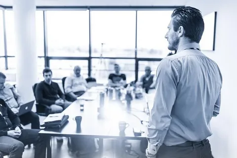 Project Management and Execution A consultant leads a meeting, symbolizing the results-driven approach of AI&GB's **expert technical and academic consulting services** in ensuring adherence to regulations and project timelines.